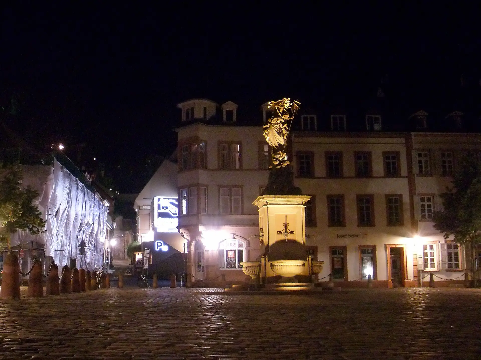 Kornmarkt mit beleuchteter Madonnenstatue bei Nacht